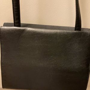 Black cross body bag with plenty of compartments to hold cards, cash keys lip